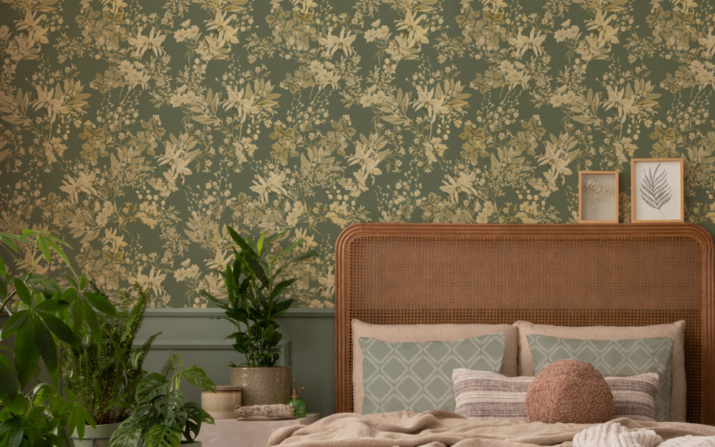 IRIS SOFT GREEN WALLPAPER with cream and. beige floral design on a wall in a bedroom with plants and natural headbord and framed leaf pictires.Part of our home decor collections