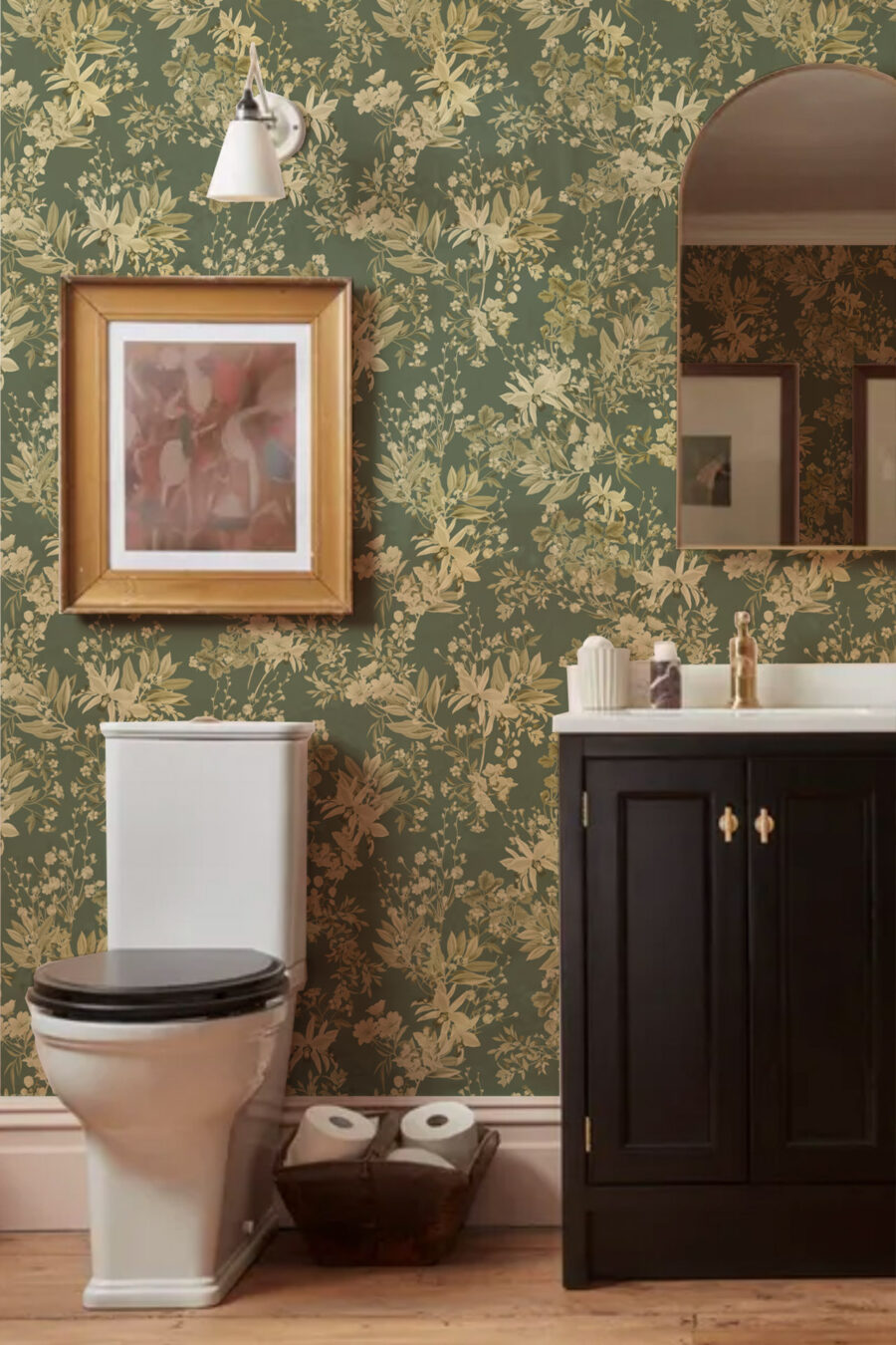 IRIS SOFT GREEN wallpaper with gold beige floral dwsign in a bathroom with a dark vanity unit and toilet and a picture on the wall with a light and mirror