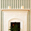 Rosalie Soft Green Wallpaper with cream background and olive green repeating abstract pattern surrounding a cream Fireplace. Mina is part of our home decor collection The Portrait Collection.