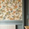 Lottie Off-white Wallpaperwith orange blue and green floral design used in hallway above an eggshell. blue pannelled area and next to a door.