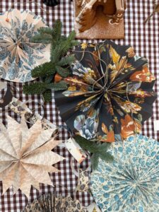 A table filled with beautiful handmade Christmas decorations made from wallpaper leftovers by Curate Space